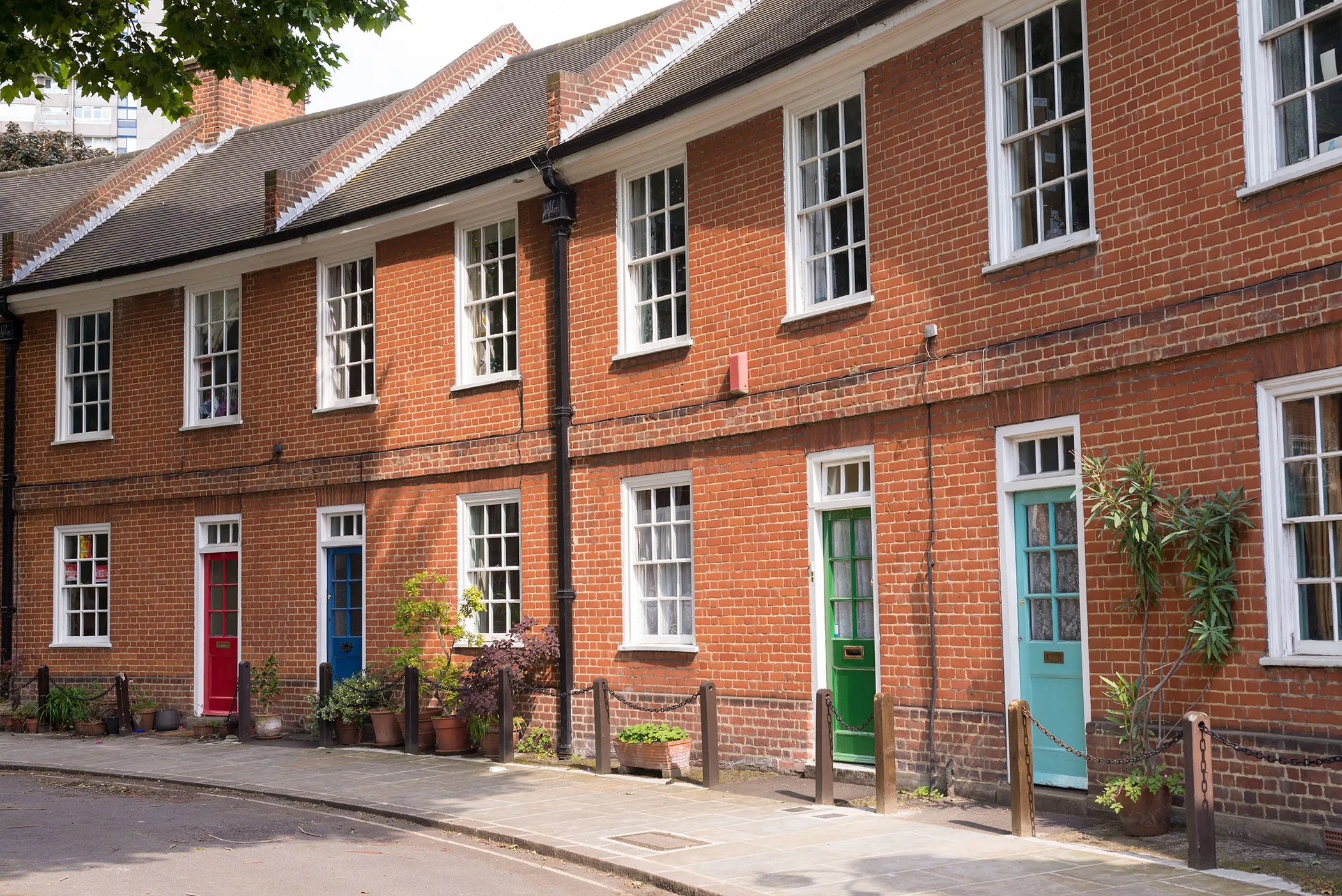 A row of red brick houses with white windows.